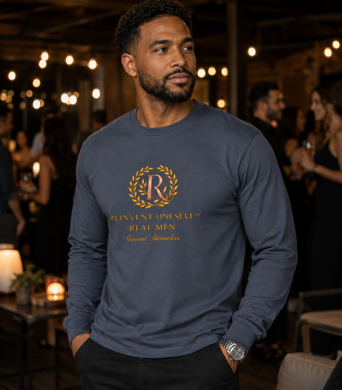 Man wearing the navy Real Men Reinvent Themselves long sleeve tee with gold crest